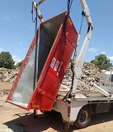 Loading and unloading a skip bin from a tip truck